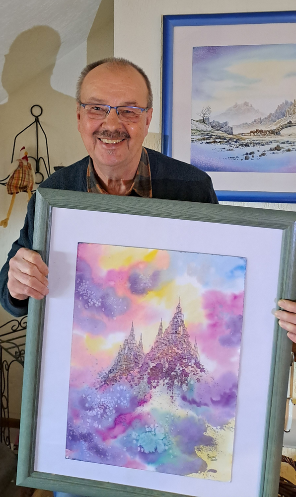 Foto des Künstlers mit einem Aquarell im Rahmen vor sich haltend.